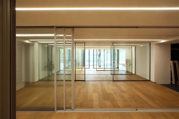 Posuvná prosklená stěna amadeus se štíhlými profily ve světlém provedení, showroom OKNA.EU Praha Pankrác