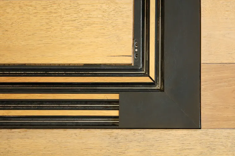 Detail rohu rámu posuvné stěny vzorkové místnosti zapuštěného do dubové podlahy, showroom OKNA.EU