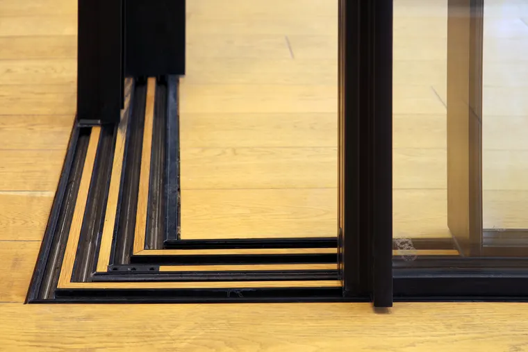Detail zapuštěné vodicí kolejnice posuvných stěn vzorkové místnosti v dubové podlaze, showroom OKNA.EU