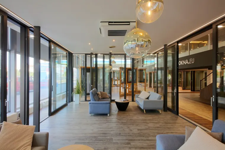 Lounge showroomu OKNA.EU Praha Pankrác s prosklenými stěnami a výhledem do výstavní plochy