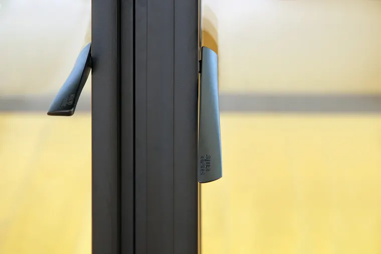 Detail kliky amadeus s vyraženým logem v tmavém provedení, showroom OKNA.EU