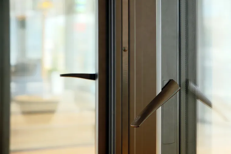 Detail kliky amadeus v tmavším kovovém odstínu na štíhlém profilu, showroom OKNA.EU