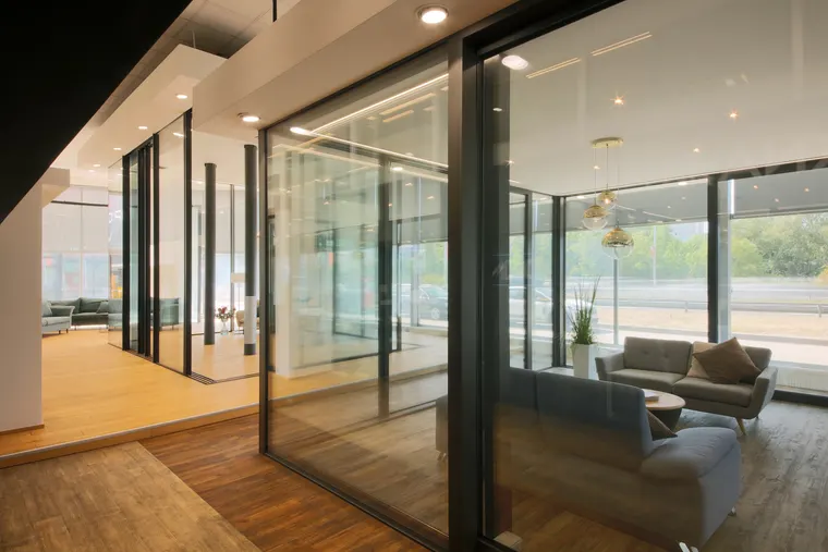 Pohled na lounge showroomu OKNA.EU přes prosklené posuvné stěny